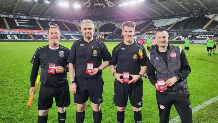 Proud match officials with their cup final medals